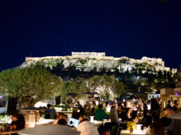 A vibrant rooftop bar in Athens overlooking the illuminated Acropolis, the perfect start to a Greece itinerary 10 days in 2026.