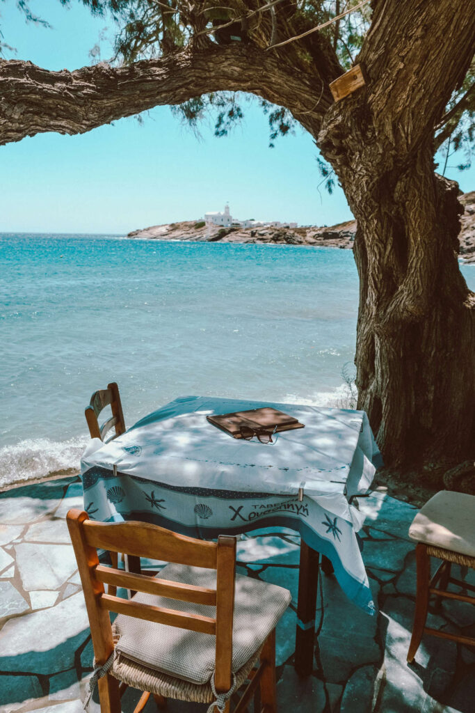 A rustic outdoor table setup with local Greek food and wine, highlighting the best Greek islands for couples in 2026 for food lovers.